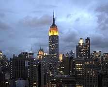 At night the Empire State Building is illuminated in the colors black, red and gold.
